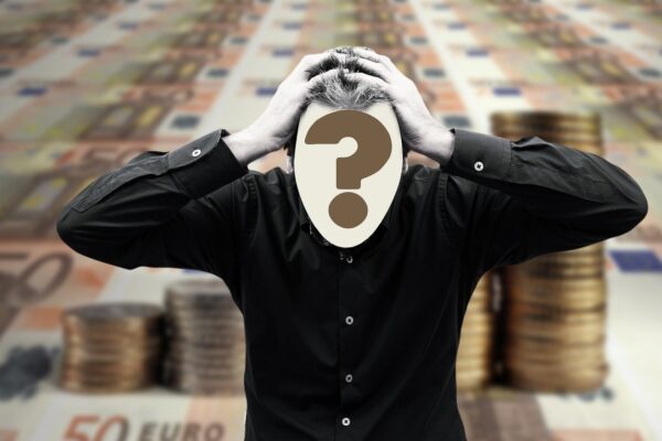A person in a black shirt clutching their head, with a large question mark obscuring their face, stands against a background of euro banknotes and stacked coins.