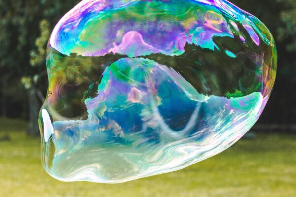 A close-up image of a soap bubble beginning to burst, symbolizing the fragile state of financial or technological markets such as the AI industry.