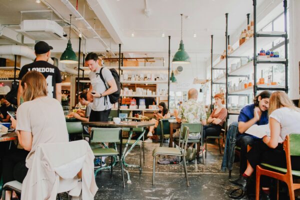People sitting and talking in a busy coffee shop, highlighting the social atmosphere of community and connection.