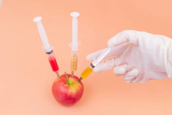 Syringes injecting colors into apple