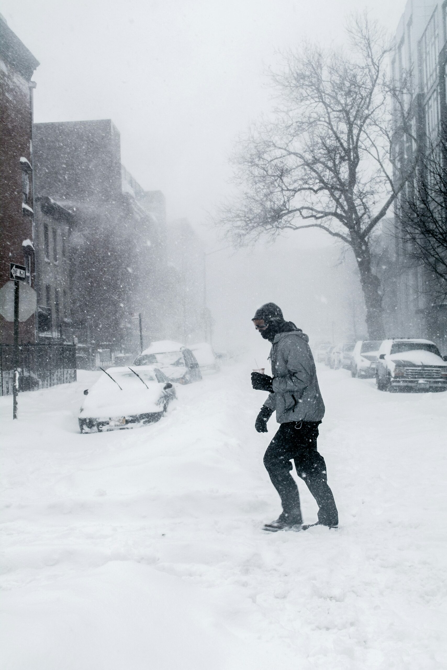Person walking in heavy snowfall, showing extreme winter weather at work.