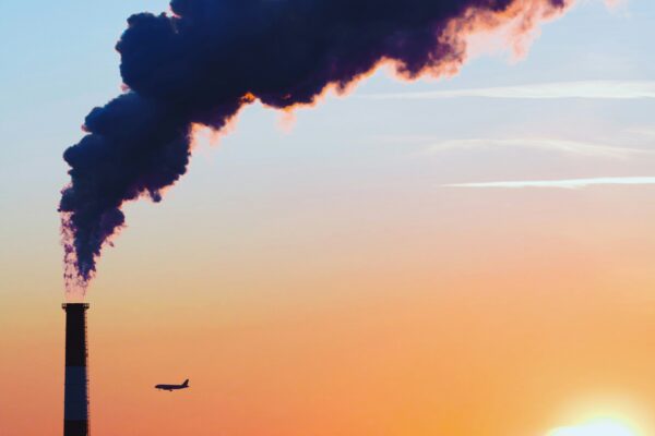 Smoke stack against sunset sky, showing what polluters really do
