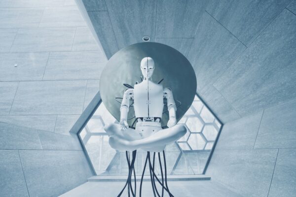 White Sci-Fi robot with a cables coming out of it sitting meditating