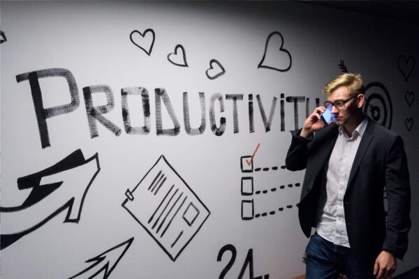 Person on phone near productivity mural