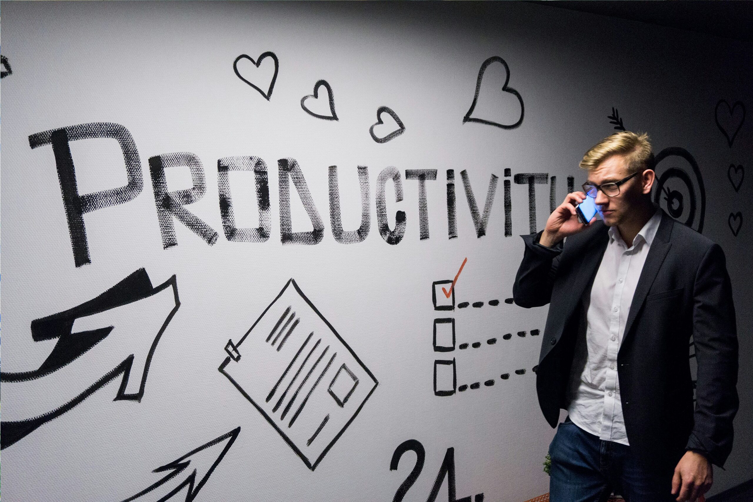 Person on phone near productivity mural