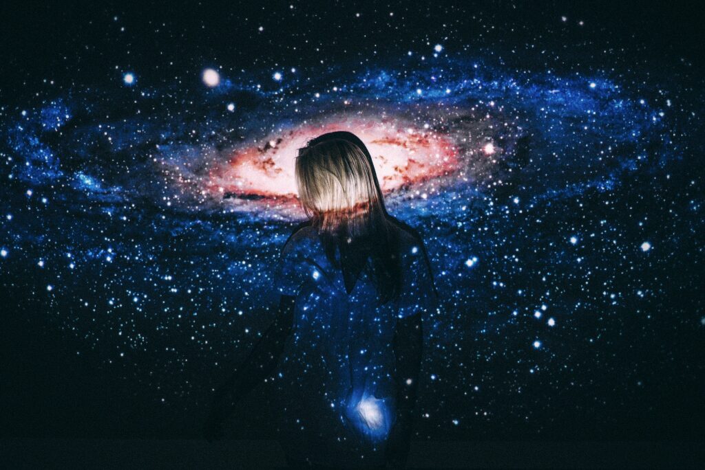 Person silhouetted against galaxy backdrop a metaphor for the idea of Consciousness in the universe