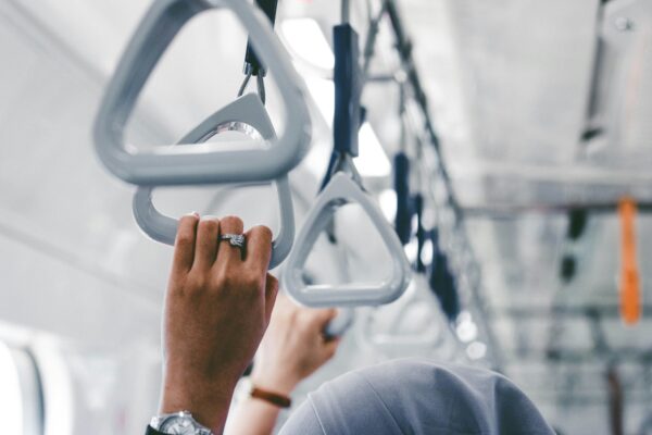 Person holding subway handrail on Public Transportation
