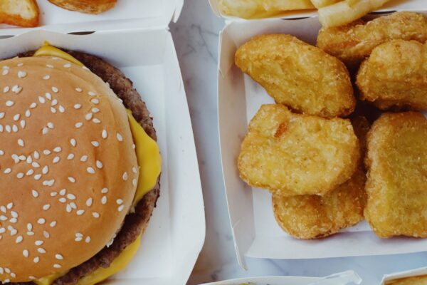 Closeup of delicious junk fast food consisting of burgers with nuggets and french fries placed on marble table