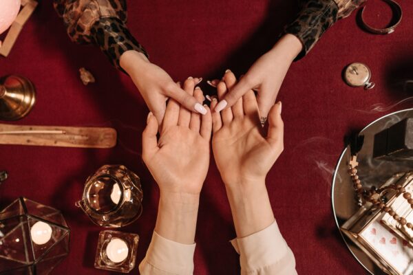 Top-down view of a mystical palm reading session with candles and spiritual objects. This is metaphoric of Predictions.