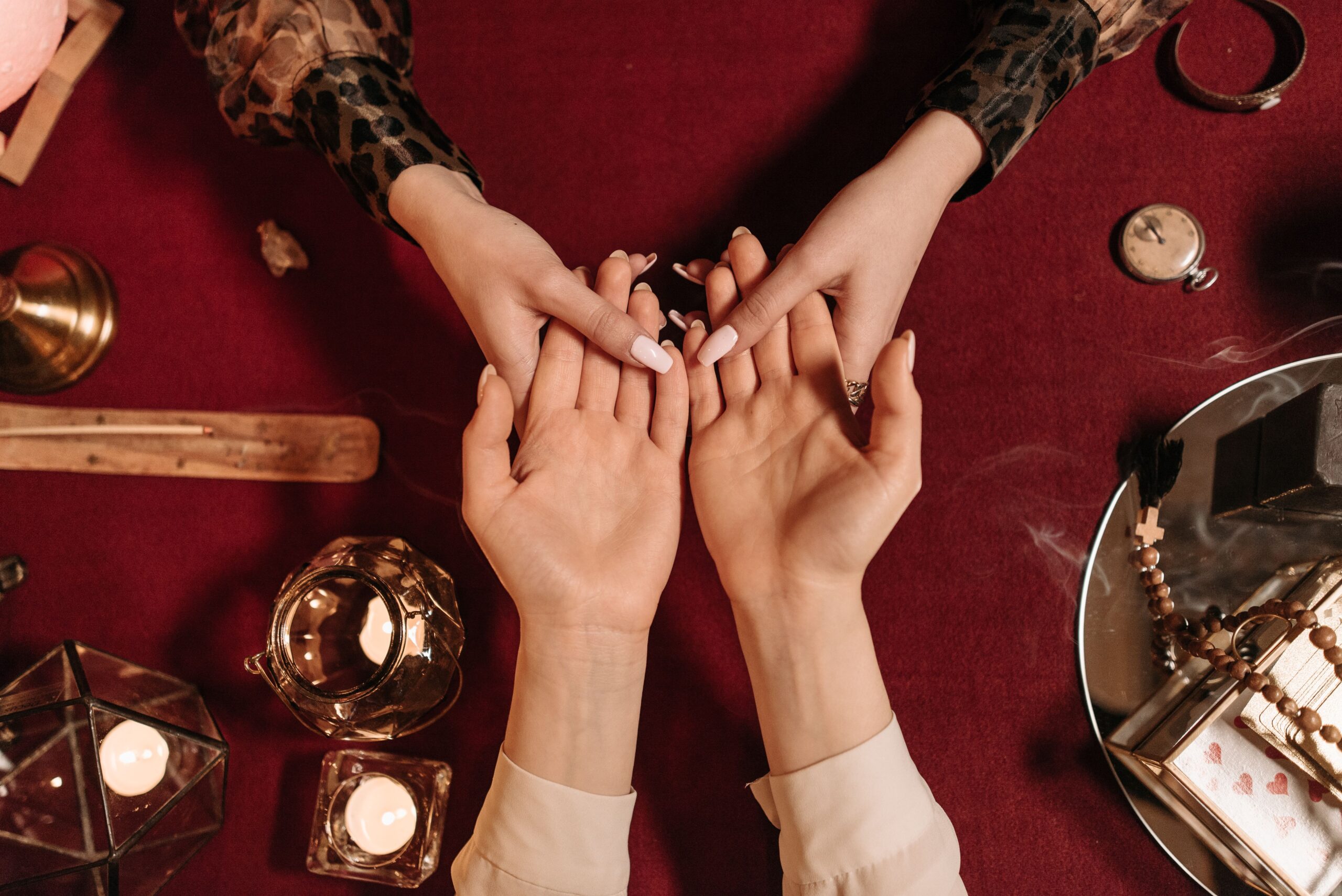 Top-down view of a mystical palm reading session with candles and spiritual objects. This is metaphoric of Predictions.