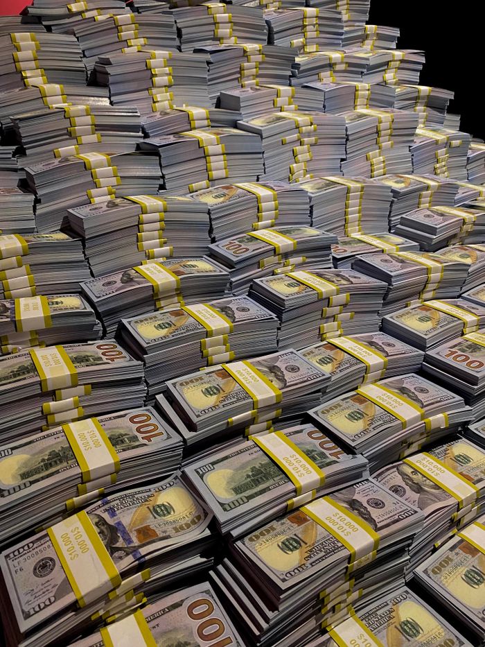 Large piles of 100 US dollar bills neatly stacked, symbolizing wealth and financial abundance.