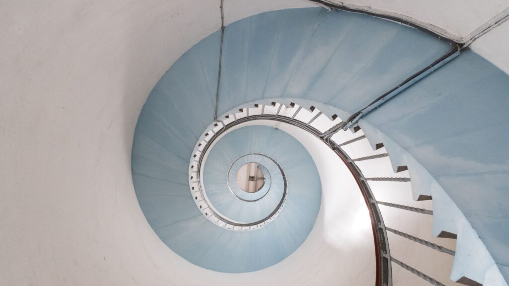 View from above of a blue spiral staircase in a lighthouse. It seems to go on forever, like certain political terms. Which is why we need term limits.
