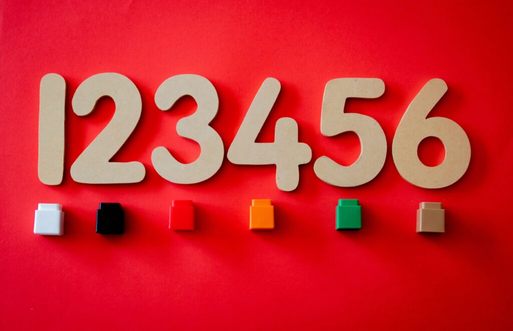 Wooden numbers with colorful blocks on vibrant red surface.